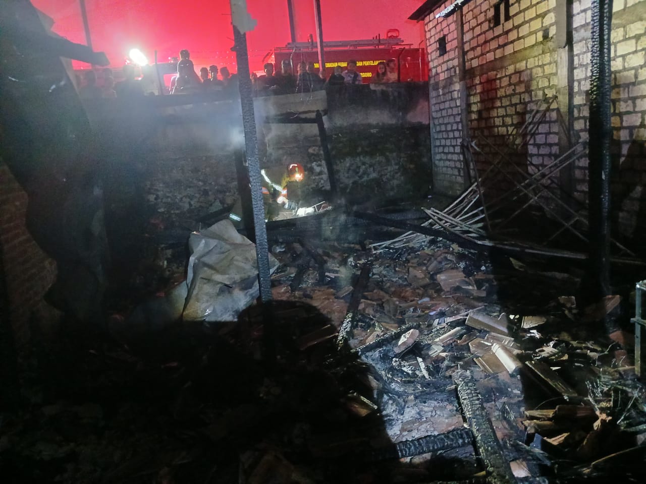 Petugas Damkarmat Bojonegoro memadamkan kebakaran rumah di Desa Sraturejo Kecamatan Baureno.