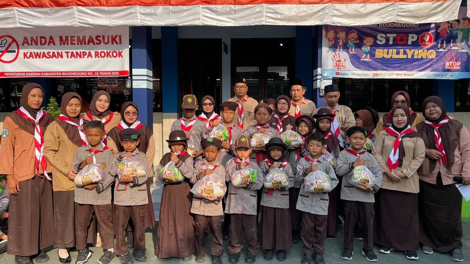 Kepala SDN Campurejo I bersama guru, murid dan peserta kegiatan berfoto bersama usai pelaksanaan Bulan Bakti Sosial dalam rangka memperingati Hari Pramuka ke-65 di TK Putra Bangsa, Bojonegoro.