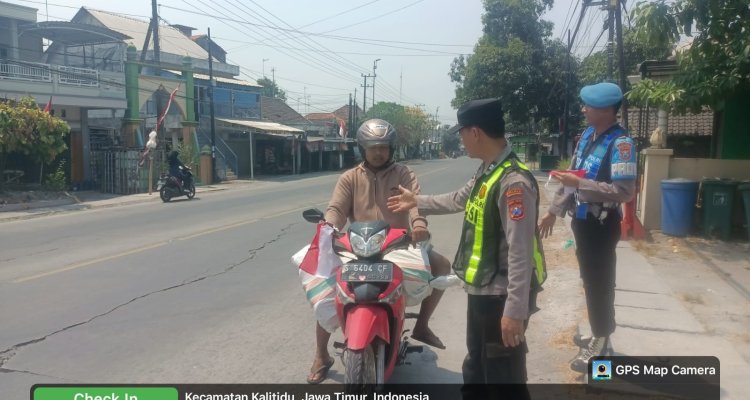 Jajaran Polres Bojonegoro membagikan bendera Merah Putih kepada pengguna jalan di wilayah Kabupaten Bojonegoro, Minggu (16/8/2026).