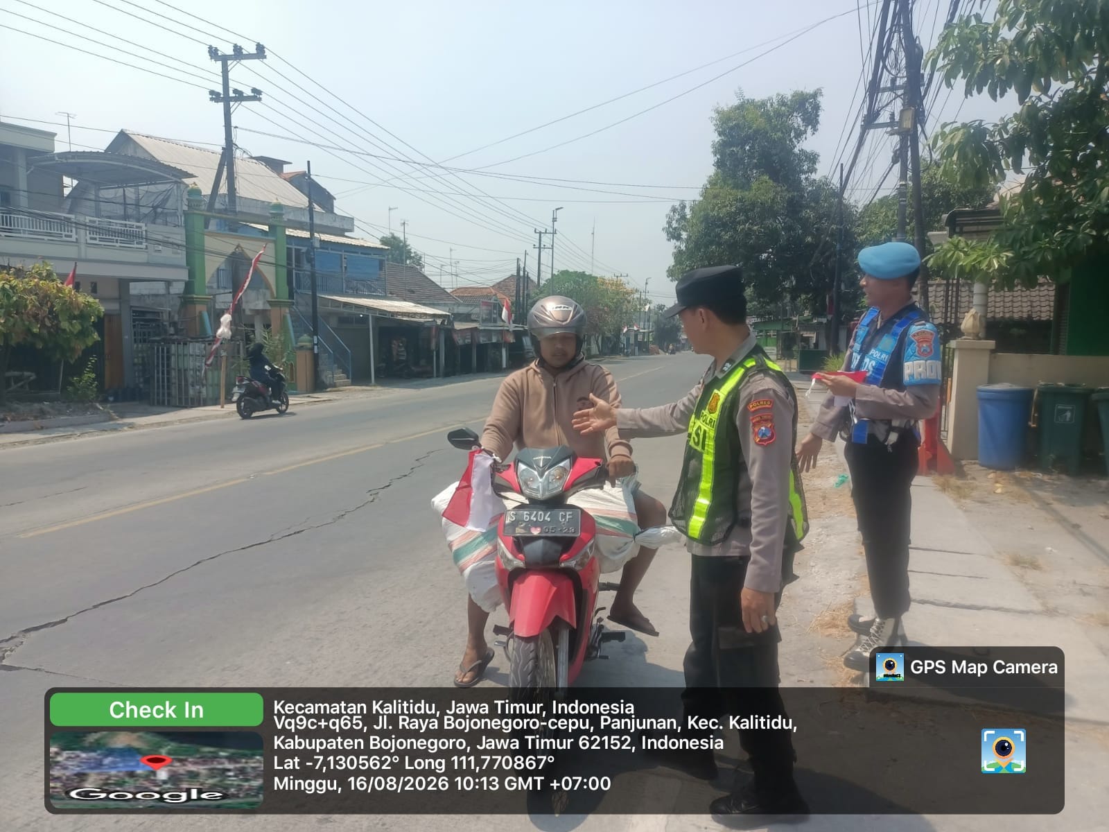 Jajaran Polres Bojonegoro membagikan bendera Merah Putih kepada pengguna jalan di wilayah Kabupaten Bojonegoro, Minggu (16/8/2026).