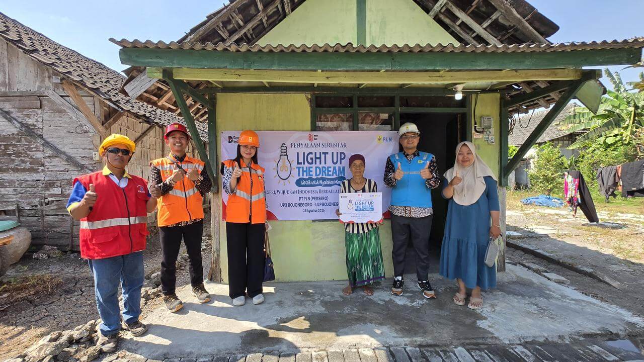Petugas PLN UP3 Bojonegoro bersama salah satu penerima manfaat berfoto usai penyalaan serentak program Light Up The Dream di rumah warga kurang mampu.