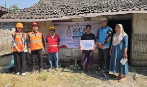 Petugas PLN UP3 Bojonegoro bersama salah satu penerima manfaat berfoto usai penyalaan serentak program Light Up The Dream di rumah warga kurang mampu.