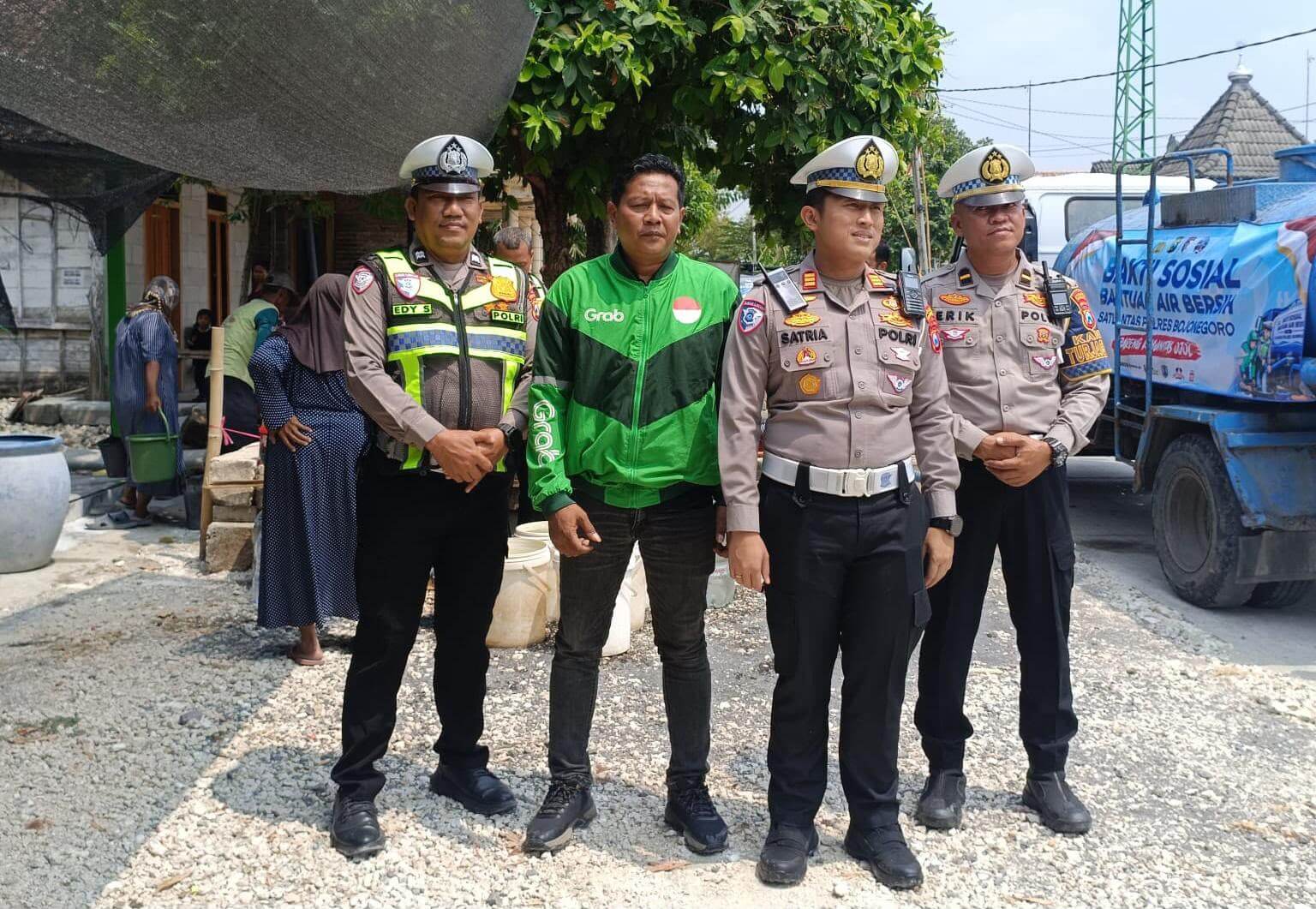 Dari kiri, Aiptu Edi S., Ketua Komunitas Ojol Bojonegoro Bersatu (OBB) Suwito alias Wio, Kasat Lantas Polres Bojonegoro AKP Satria Dwi Aryanto, S.Tr.K., S.I.K., dan Kanit Turjawali Satlantas Polres Bojonegoro Ipda Erik Kurniawan, S.H., saat kegiatan bakti sosial penyaluran bantuan air bersih kepada masyarakat di Bojonegoro.