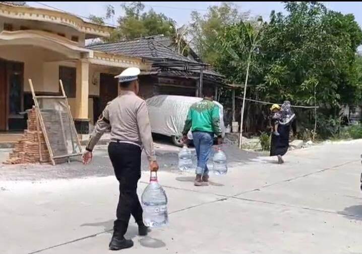 Anggota Satlantas Polres Bojonegoro bersama anggota OBB turut membawakan air bersih menuju rumah warga yang lokasinya cukup jauh dari titik dropping.