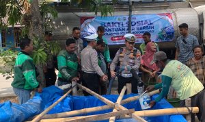 Kasatlantas Polres Bojonegoro AKP Satria Dwi Aryanto bersama jajaran Satlantas dan Komunitas Ojol Bojonegoro Bersatu (OBB) saat menyalurkan bantuan air bersih kepada warga dalam rangkaian bakti sosial Hari Lalu Lintas ke-71.