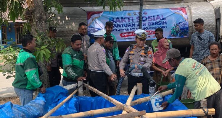 Kasatlantas Polres Bojonegoro AKP Satria Dwi Aryanto bersama jajaran Satlantas dan Komunitas Ojol Bojonegoro Bersatu (OBB) saat menyalurkan bantuan air bersih kepada warga dalam rangkaian bakti sosial Hari Lalu Lintas ke-71.