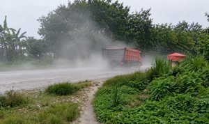 Sejumlah truk melintas di jalan proyek Jambaran Tiung Biru (JTB) di wilayah Desa Bandungrejo, Bojonegoro, sementara debu tampak berterbangan dan dikeluhkan mengganggu warga sekitar.
