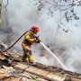 Petugas Damkarmat Kabupaten Bojonegoro melakukan pemadaman kebakaran di area lahan belakang SMP dan SMA Kalitidu, Selasa (29/9/2026).