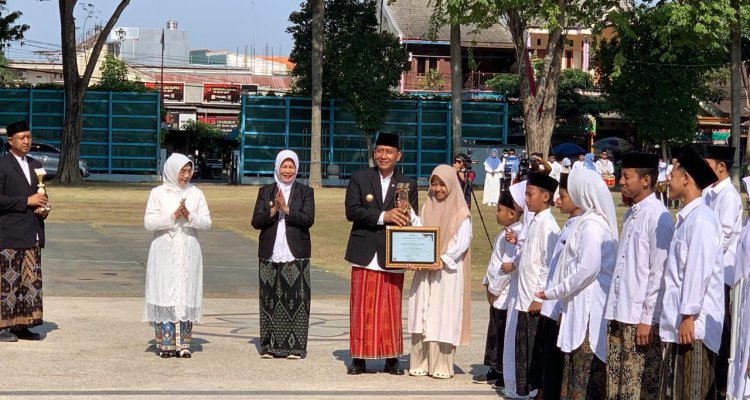 Bupati Bojonegoro Setyo Wahono menyerahkan piagam penghargaan kepada salah satu santri dalam rangkaian peringatan Hari Santri Nasional 2026 di Alun-Alun Kabupaten Bojonegoro, Kamis (22/10/2026).