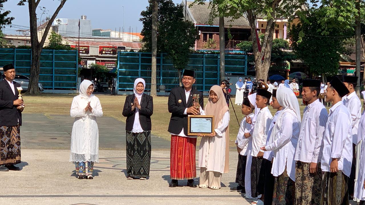 Bupati Bojonegoro Setyo Wahono menyerahkan piagam penghargaan kepada salah satu santri dalam rangkaian peringatan Hari Santri Nasional 2026 di Alun-Alun Kabupaten Bojonegoro, Kamis (22/10/2026).