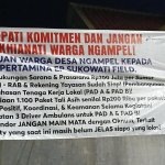 Spanduk tuntutan warga Desa Ngampel terkait aspirasi kepada Pertamina EP Sukowati sebelum mediasi digelar pada 26 Oktober 2026.