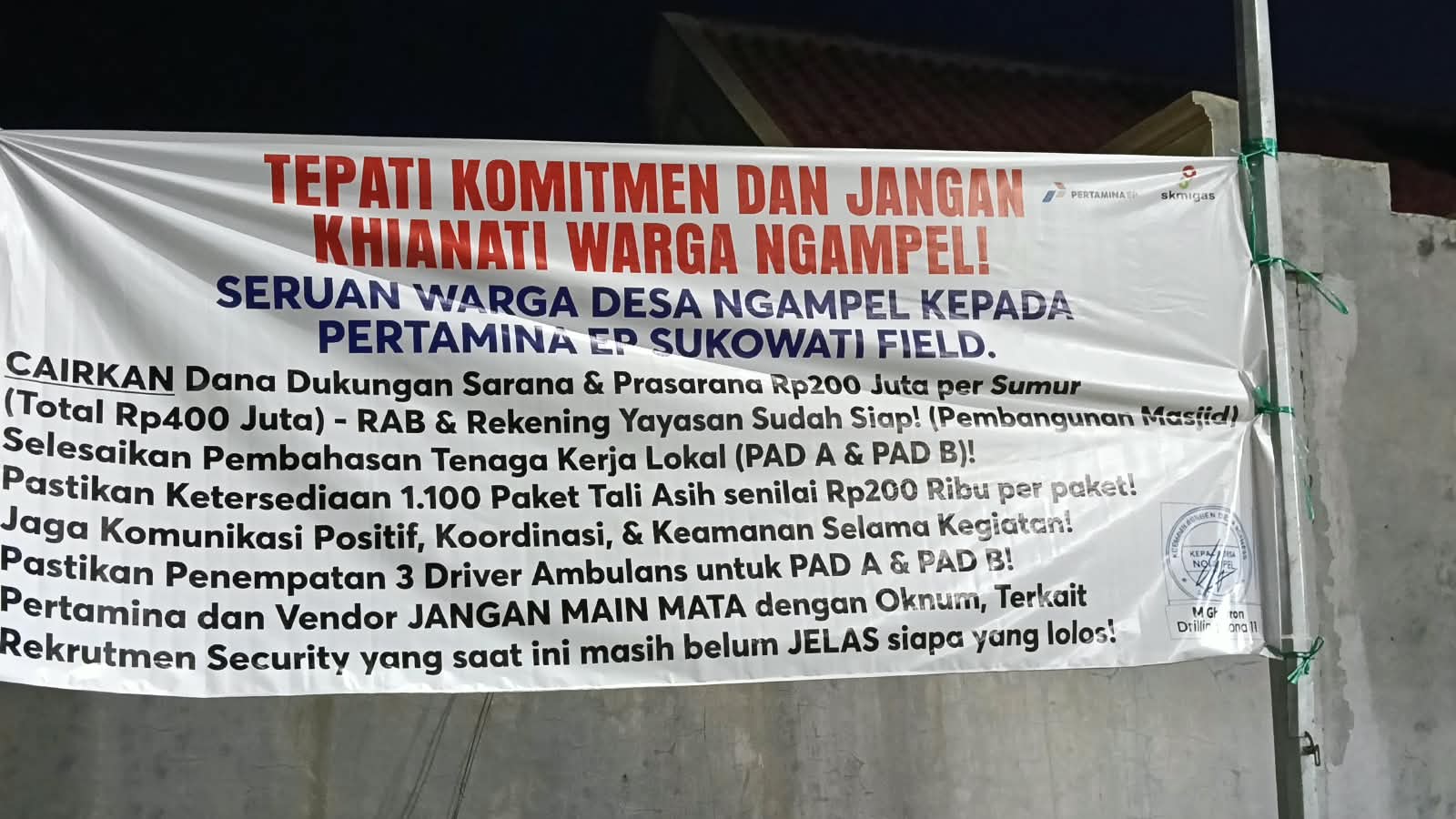 Spanduk tuntutan warga Desa Ngampel terkait aspirasi kepada Pertamina EP Sukowati sebelum mediasi digelar pada 26 Oktober 2026.